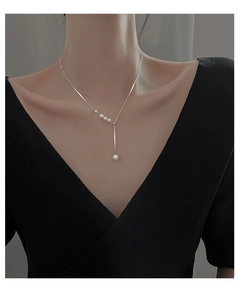 Close-up of elegant silver Y-shaped pearl necklace on model for a minimalist chic look