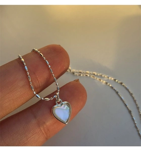 Macro di una collana cuore in argento S925 con inserto in madreperla naturale cangiante