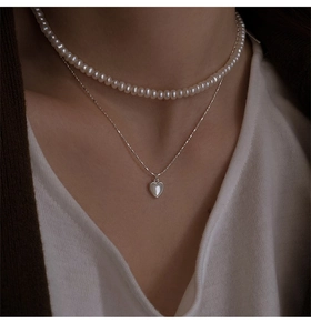 Dettaglio di una collana doppia in argento S925 con perle e pendente a cuore in conchiglia