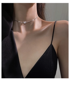 Close-up of sparkling 925 sterling silver butterfly pendant choker on woman neckline