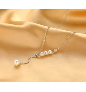 Detail of elegant silver choker with cascading shell pearls on golden silk background