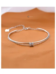 Detail of s925 silver double-layer bracelet with heart charm and sparkling crystals