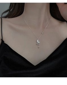 Gros plan du collier lune et étoile en argent S925 porté par un mannequin femme