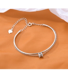 Detail of s925 silver double-layer bracelet with heart charm and cubic zirconia rings