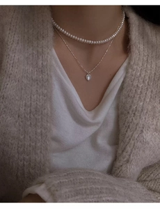 Dettaglio della collana a doppio strato in argento S925 con pendente a cuore e perle bianche