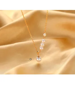 Detail of silver pearl necklace with five gradient pearls on a gold silk background