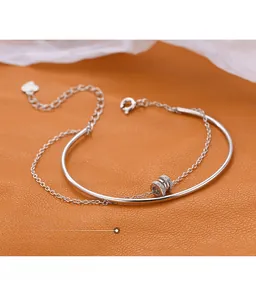 Detailed macro view of S925 sterling silver double-layered bracelet with pavé crystal charm