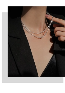 Double-layered 925 silver butterfly necklace worn over stylish black business attire