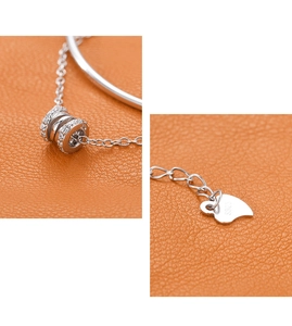 Macro shot of S925 sterling silver cylinder pendant and heart-shaped logo tag on leather