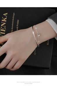 Detail of s925 silver double-layered bracelet with crystal cylinder and heart pendant