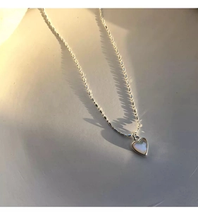 Dettaglio ravvicinato di una collana a cuore in argento s925 con intarsio in conchiglia