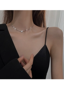 Detail of elegant butterfly necklace in 925 silver worn on model collarbone area