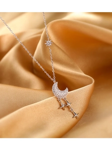 Détail macro du collier lune en argent S925 avec zircons scintillants sur du satin