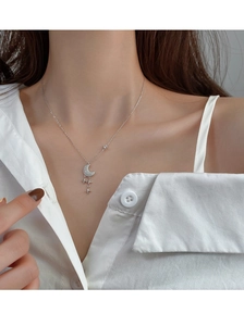 Détail du collier s925 en argent avec lune et étoiles sur le cou d'une femme