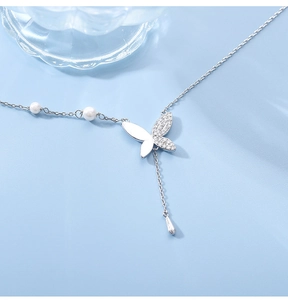 Détail du pendentif papillon en argent avec pierres pavées et perles élégantes