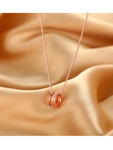Gros plan d'un collier double anneau en or rose serti de zircons sur fond de soie