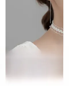 Vue détaillée de boucles d'oreilles nœud en argent s925 sur le cou du mannequin avec dentelle