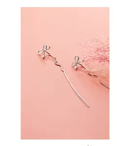 Détail macro de boucles d'oreilles nœud en argent S925 avec zircons et glands élégants