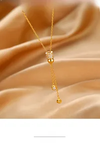 Gros plan d'un collier lasso en argent S925 doré avec cylindre pavé de zircons fins