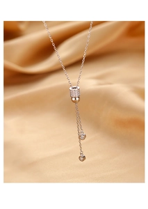 Détail du collier en argent s925 avec pampilles scintillantes sur fond de soie champagne