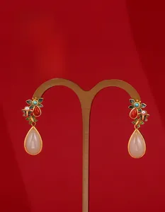 Detailed macro view of ethnic silver earrings with cloisonne enamel flowers and jade drops