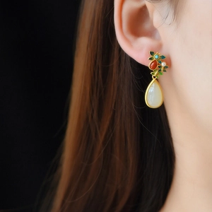 Ethnic style teardrop earrings with white jade and colorful butterfly detail on model