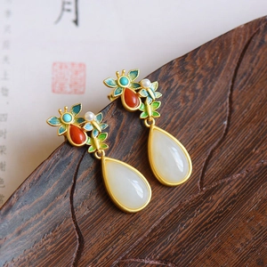 Detail of ethnic style enamel butterfly earrings with teardrop jade pendant and pearls