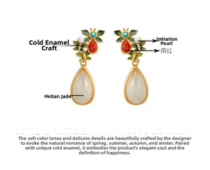 Macro detail of ethnic gold earrings with Hetian jade drops and enamel leaf patterns