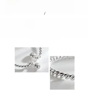 Macro view of twisted silver bangle texture with detailed hollow bell charms
