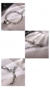 Macro detail of S925 sterling silver lucky cat bell and engraved coin charms on a chain
