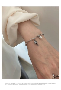 Detail showing vintage silver bracelet with mushroom charm and textured woven ring