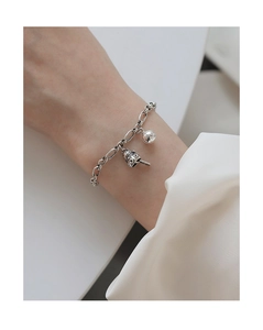 Detailed view of silver cat bell bracelet with polished beads and textured charms
