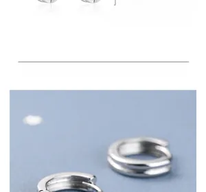 Détail macro de boucles d'oreilles créoles doubles géométriques en argent minimaliste