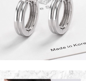 Détail de boucles d'oreilles créoles doubles géométriques en argent S925 sur carte blanche