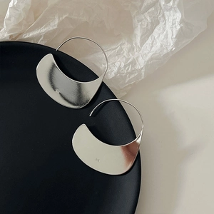 Detailed macro view showing the 925 hallmark on irregular silver crescent hoop earrings