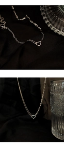 Detail der s925 Silber Herzkette mit asymmetrischer Kette vor einem Seidenhintergrund