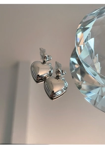 Gros plan de boucles d'oreilles cœur en argent avec finition polie et décor en cristal