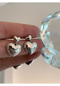 Détail macro de boucles d'oreilles cœur en argent S925 avec finition polie miroir