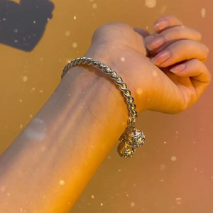 Elegant twisted wire silver bangle featuring double jingling bells on a model wrist