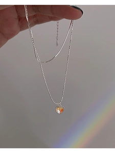 Detail of s925 silver double layer necklace with a heart pendant and iridescent moonstone