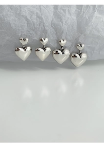 Vue détaillée des boucles d'oreilles double cœur en argent S925 au fini poli