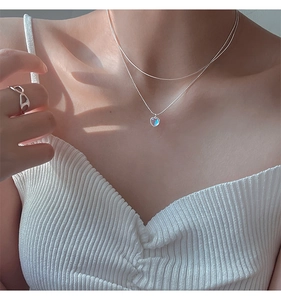 Detail of 925 sterling silver layered necklace with heart pendant on model neckline