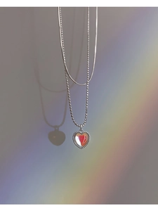 Close-up of double-layer S925 silver necklace with heart pendant and soft rainbow lighting