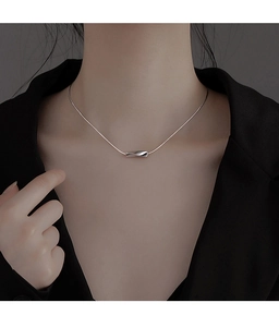 Gros plan du pendentif cylindre argenté torsadé sur une chaîne fine pour femme