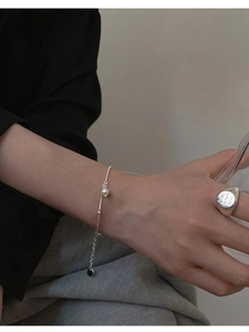 Minimalist silver chain bracelet with white pearl and black charm plus signet ring