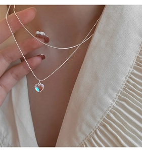Detail of double-layered 925 silver necklace with aurora heart pendant on model