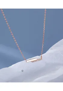 Nahaufnahme der roségoldenen Balkenkette mit Zirkonia-Inlay auf einem blauen Hintergrund