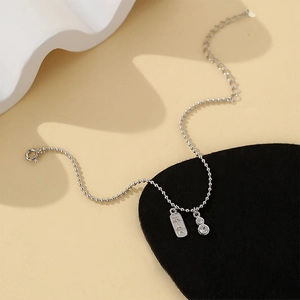 Détail du bracelet à perles argentées avec médaille Pingan et pendentif gourde cristal