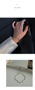 Détail du bracelet argenté ondulé avec chaîne réglable sur la manche d'un costume noir
