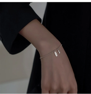 Détail du bracelet en perles d'argent avec pendentif Ping'an et breloques en zircon brillant
